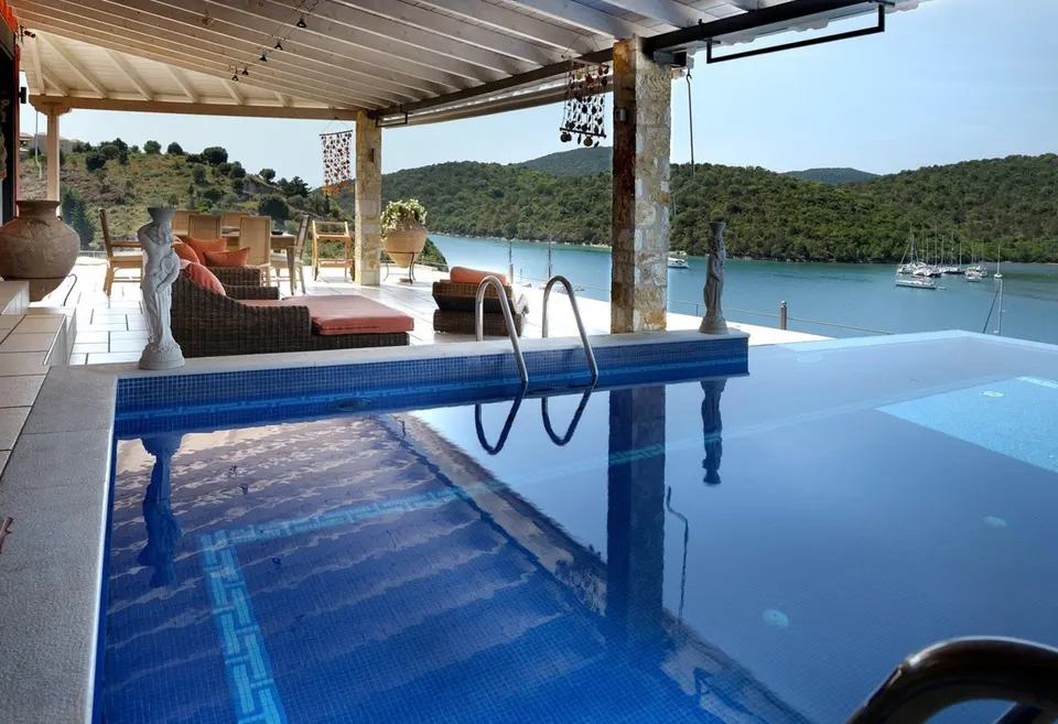 Pool and pergola with sailing yachts moored in the bay behind
