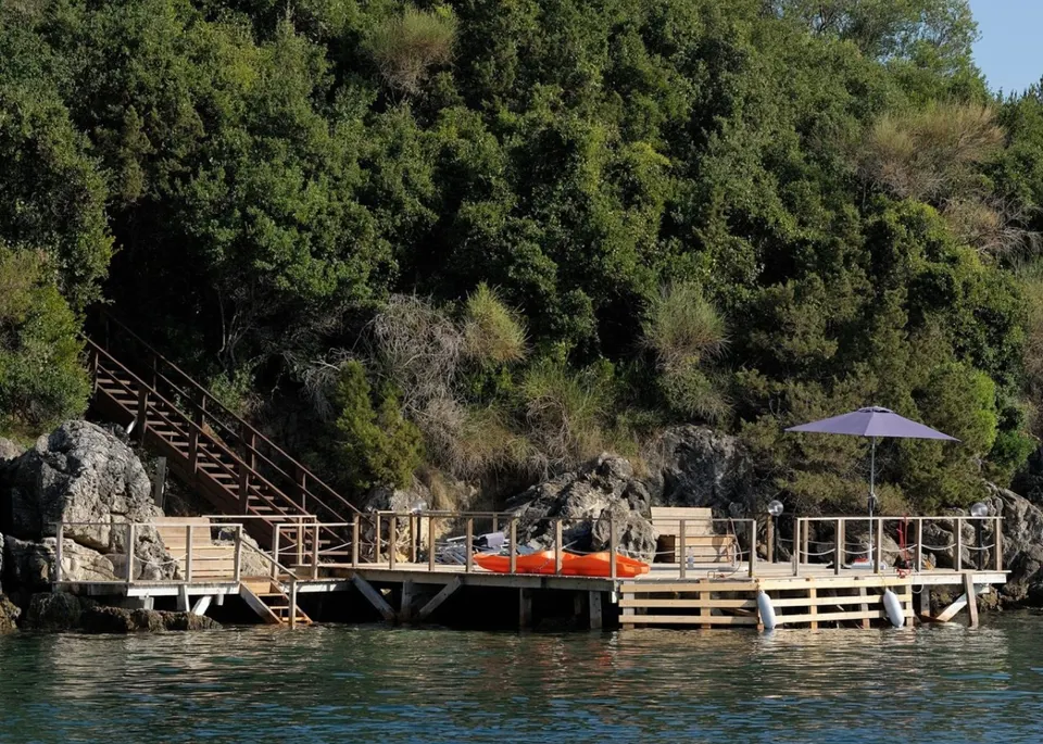 The private timber dock cut into the rocks, with kayak and mooring fenders